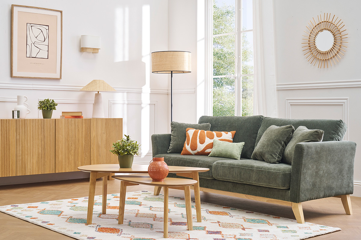 Salon avec canap� vert, lampadaire, tables basses et lampe � poser JUNI sur buffet.
