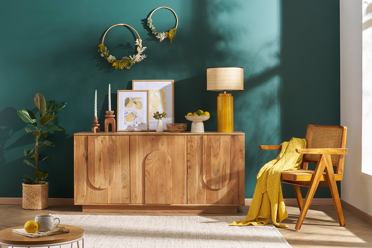 Lampe en c�ramique jaune et raphia sur un buffet en bois.