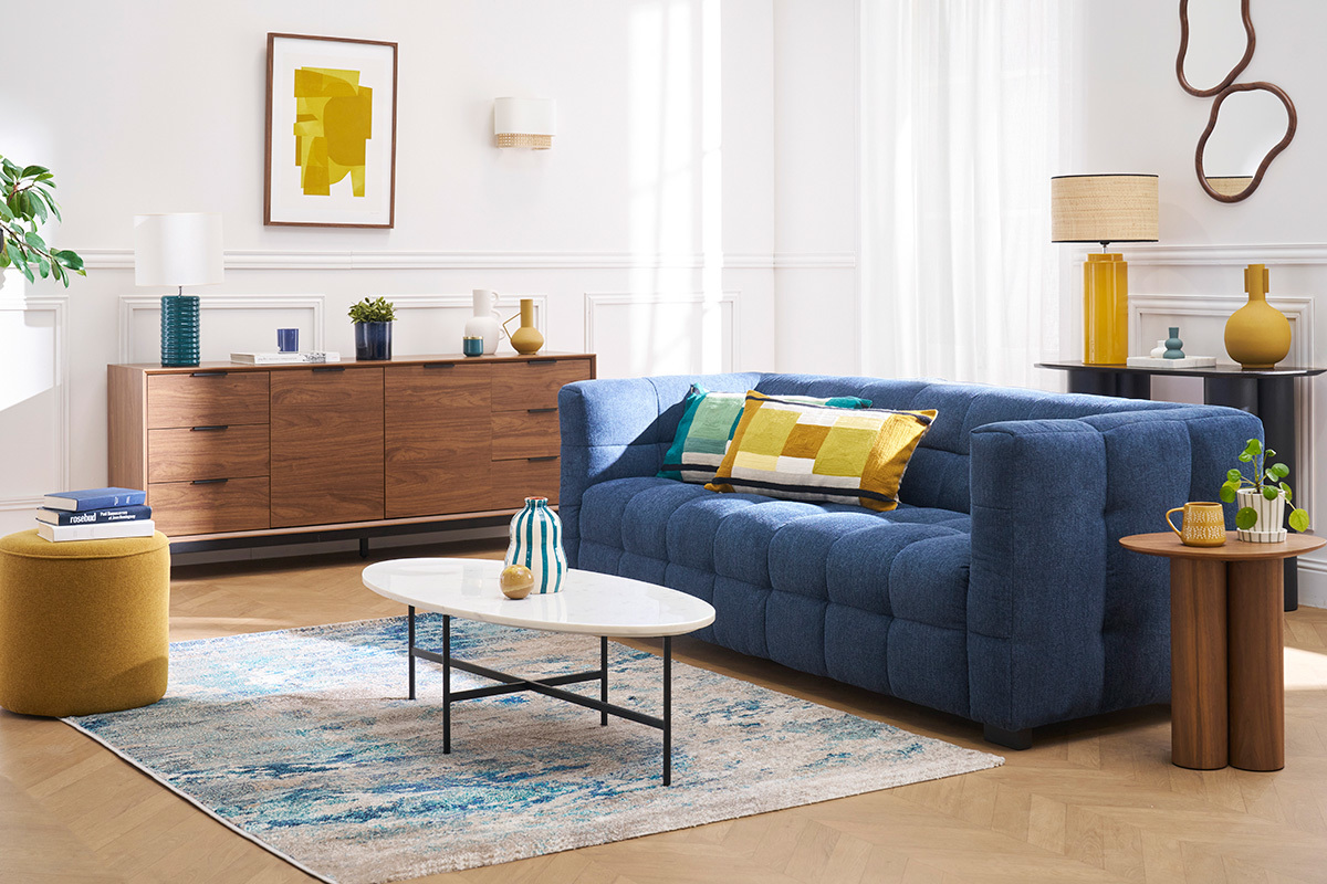 Lampe � poser jaune avec abat-jour en raphia sur une table dans un salon moderne.