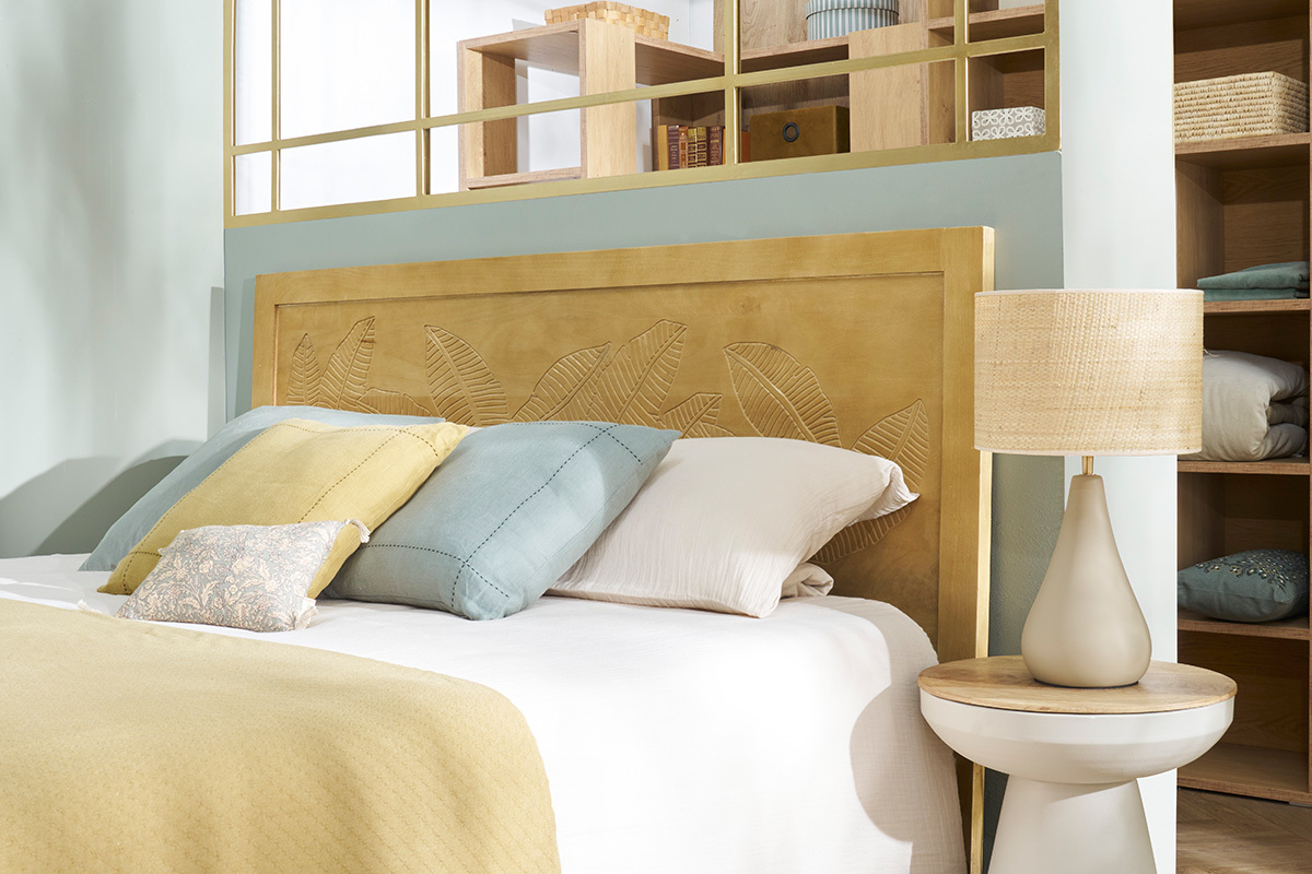 Lampe � poser taupe en c�ramique sur table de chevet avec abat-jour en raphia.