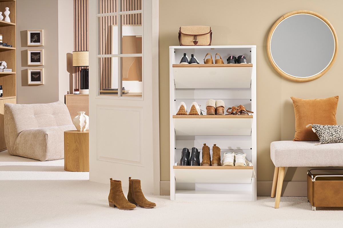 Vue de face d'un meuble � chaussures blanc � trois portes, avec des chaussures expos�es.
