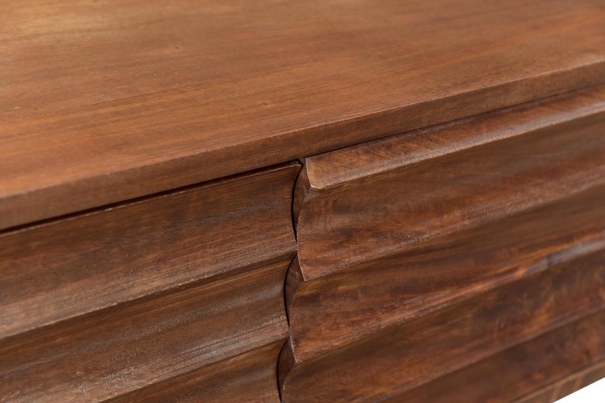 Gros plan sur le bois fonc� sculpt� du meuble TV ONDA en manguier massif.