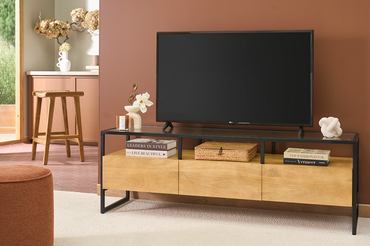 Meuble TV DIYA en bois de manguier, m�tal noir et verre avec d�cor, vue de face, TV pos�e dessus.