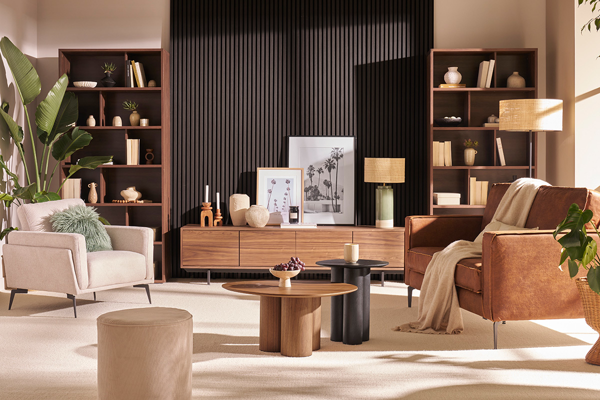 Salon avec meuble TV bois fonc� et m�tal noir, entour� de canap�s, table basse et plantes.