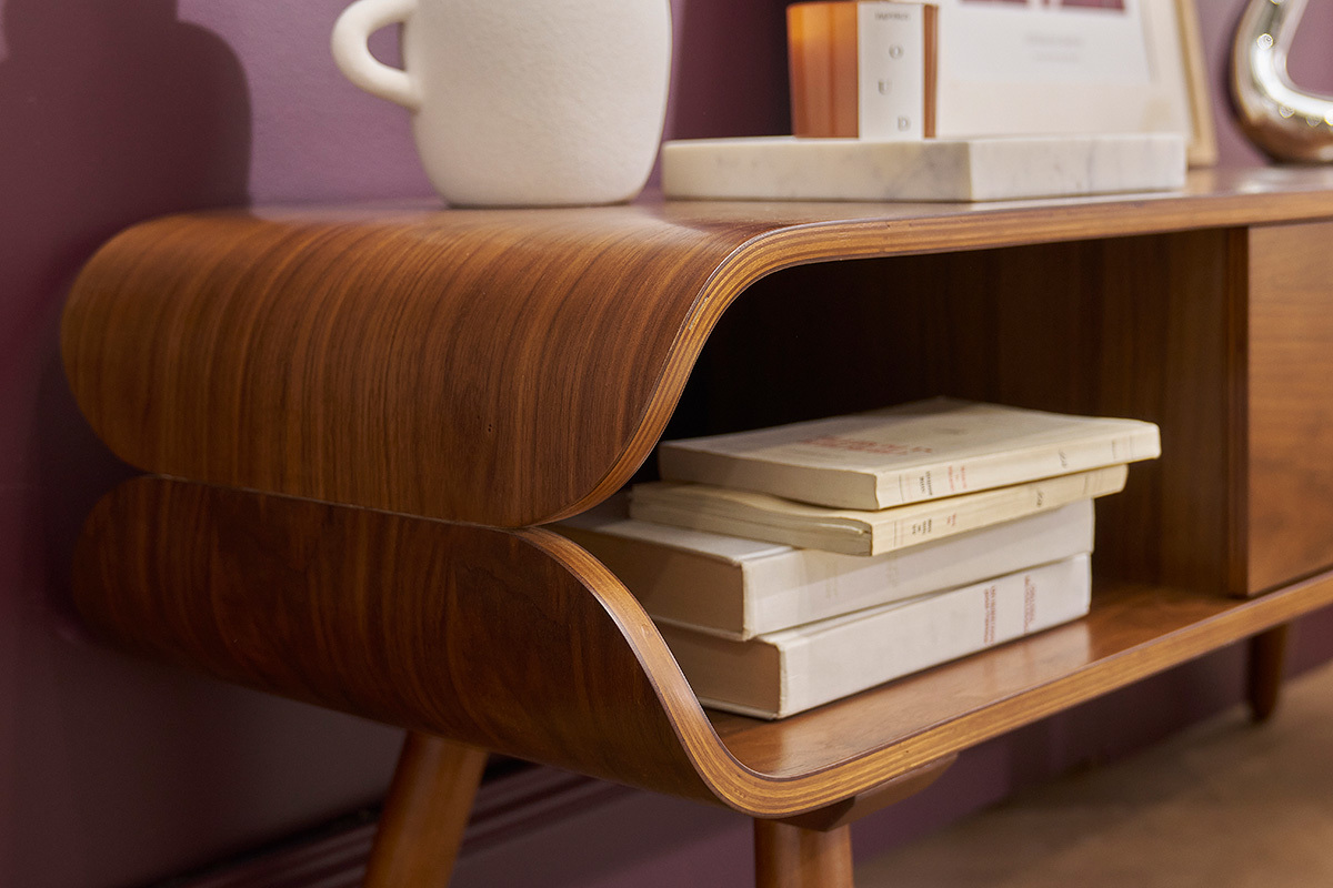 D�tail du meuble TV TAKLA en bois fonc�, niche avec livres, design vintage.