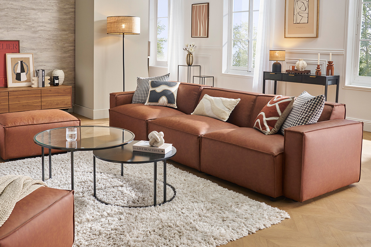 Salon avec un canap� cuir marron, coussins, tables basses en verre, et d�co murale.
