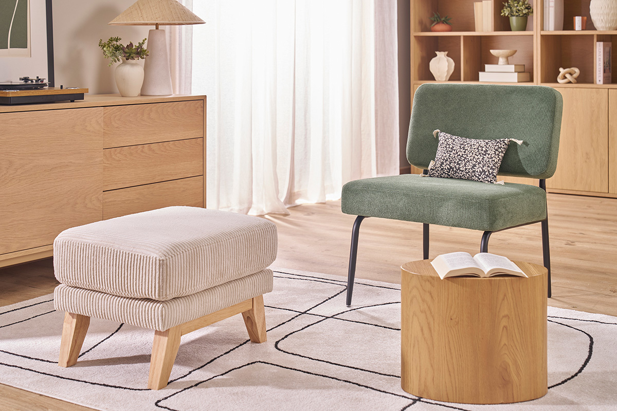 Pouf beige en velours c�tel� avec pieds en bois clair dans un salon moderne.