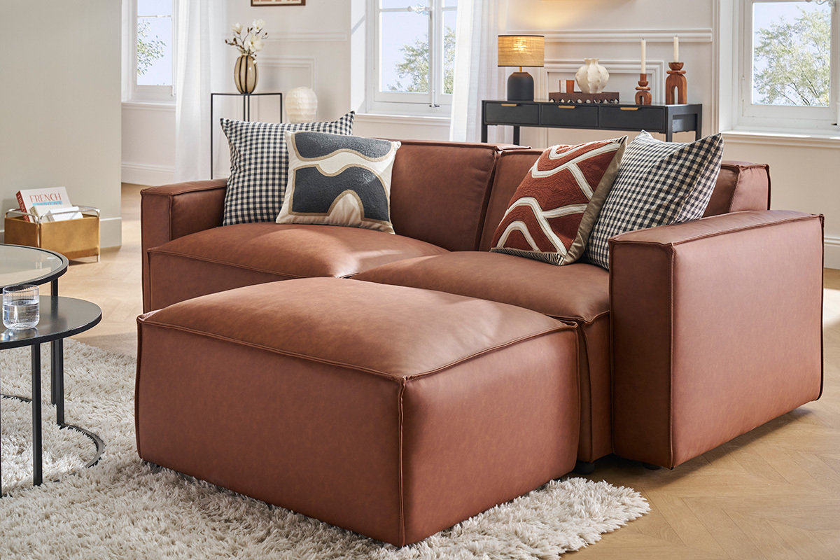 Pouf en cuir marron SPLIT devant canap� assorti, vue de 3/4.