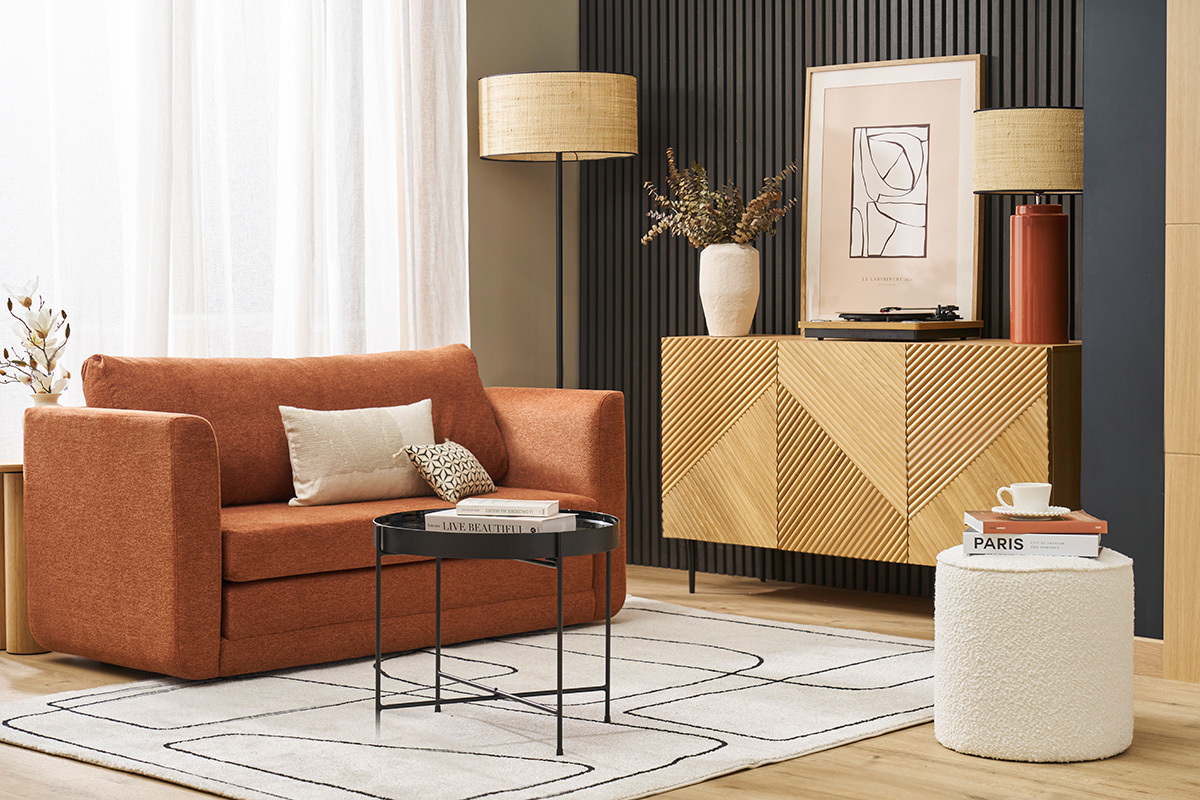 Salon avec canap� orange, table basse, buffet en bois et pouf rond blanc.