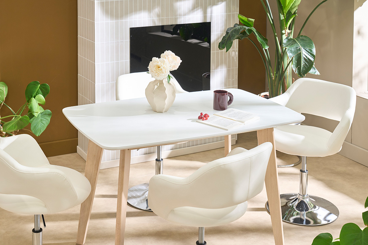 Table � manger design blanche avec bois clair, vue de dessus, entour�e de chaises blanches.