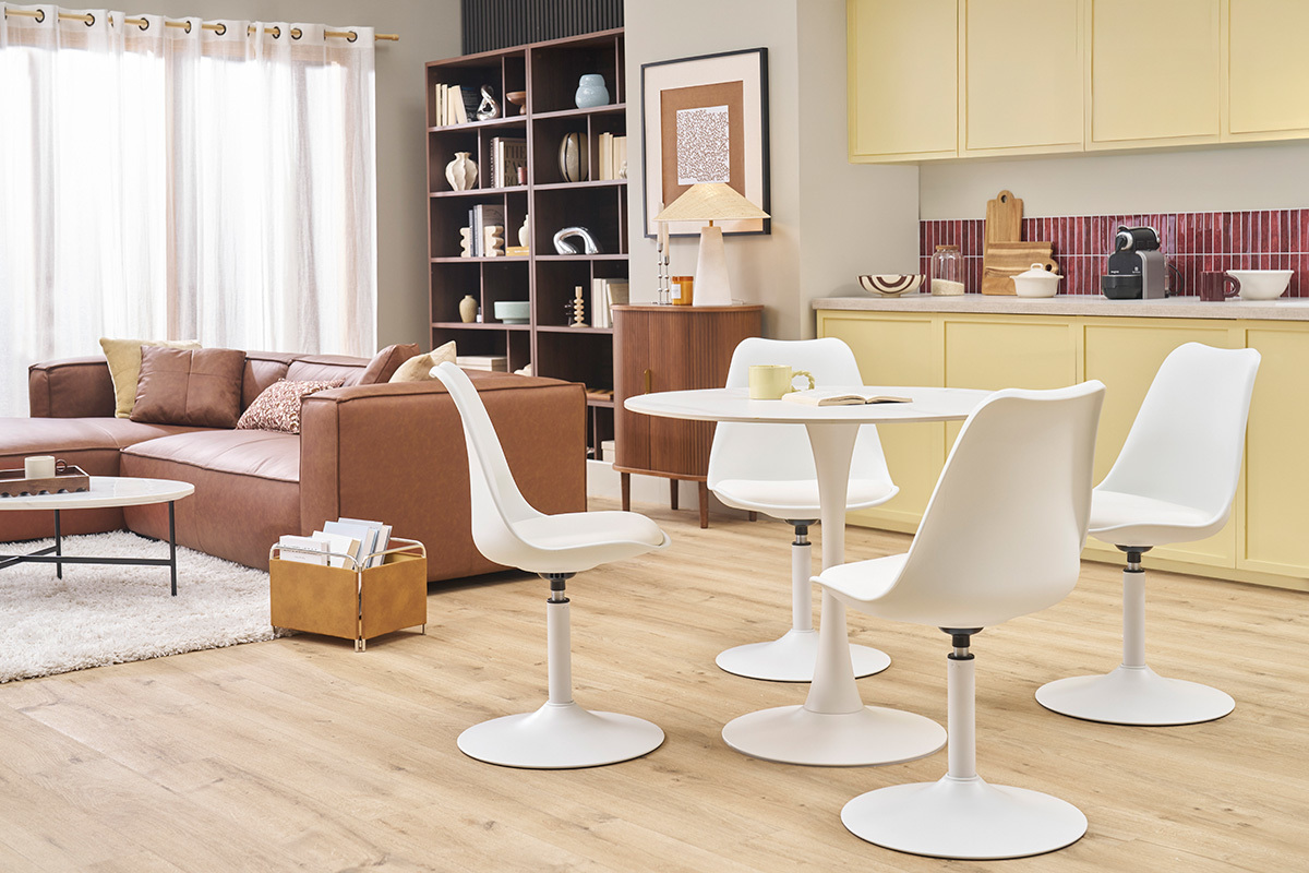 Table � manger ronde en c�ramique blanche, quatre chaises blanches, int�rieur moderne.
