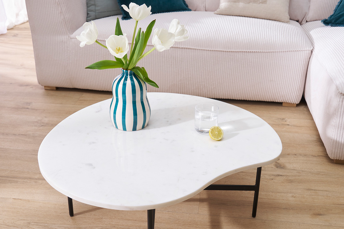 Table basse en marbre blanc avec vase et verre, vue de dessus.