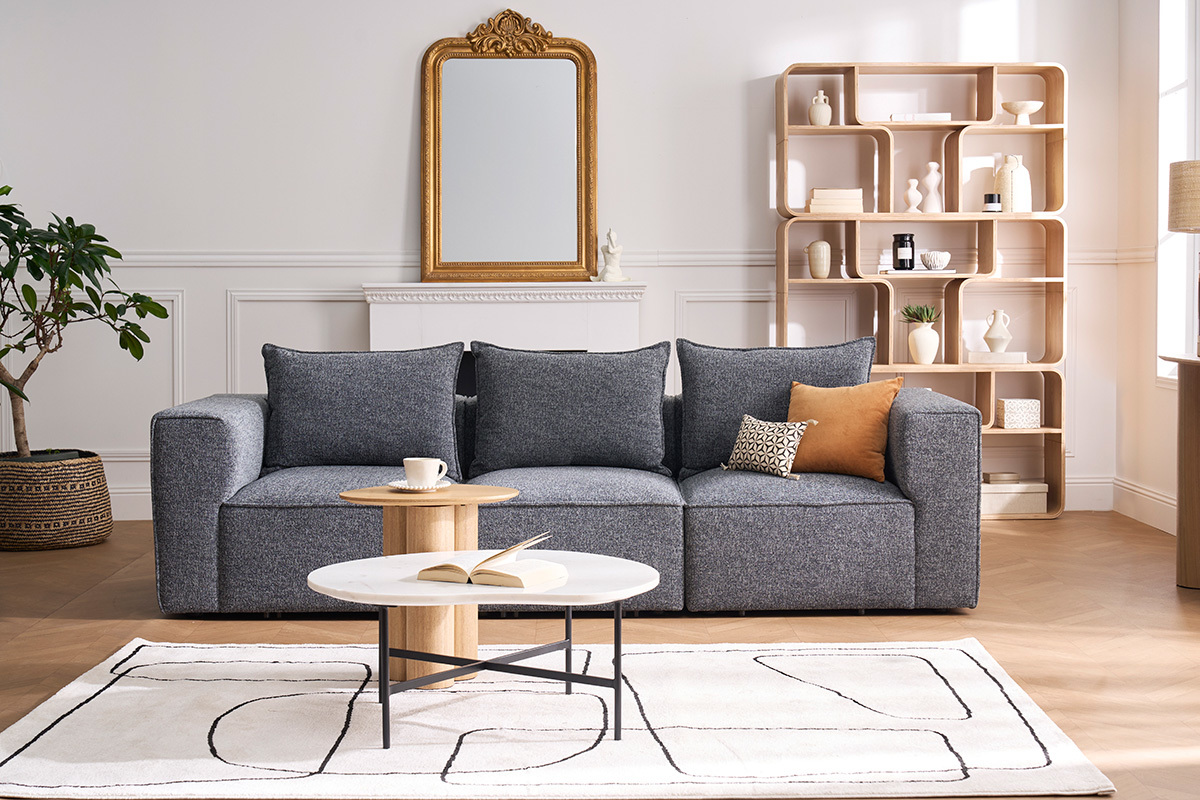 Salon avec table basse en marbre blanc et m�tal noir, canap� gris et �l�ments d�coratifs.