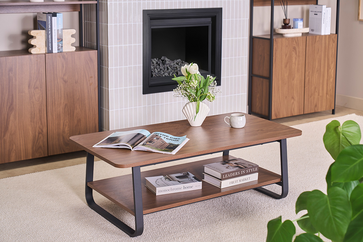 Table basse rectangulaire en bois noyer et m�tal avec magazines et vase, vue de dessus.