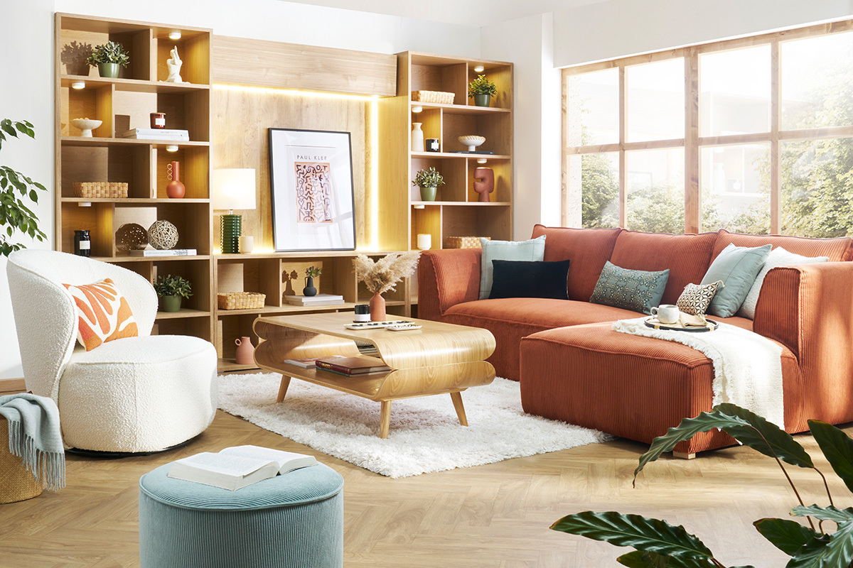 Table basse scandinave bois clair dans salon moderne avec canap� orange et �tag�res en bois.