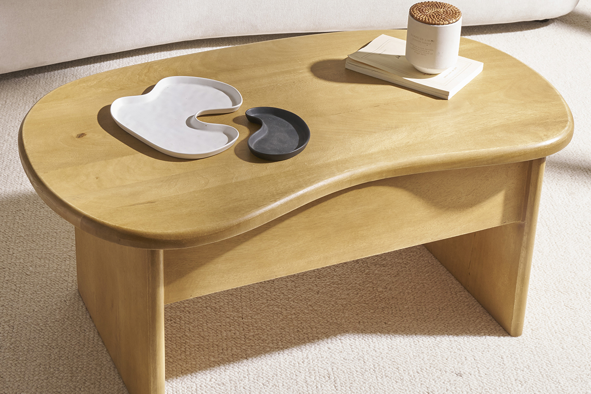 Table basse relevable en bois manguier, forme haricot, vue de dessus avec objets dessus.
