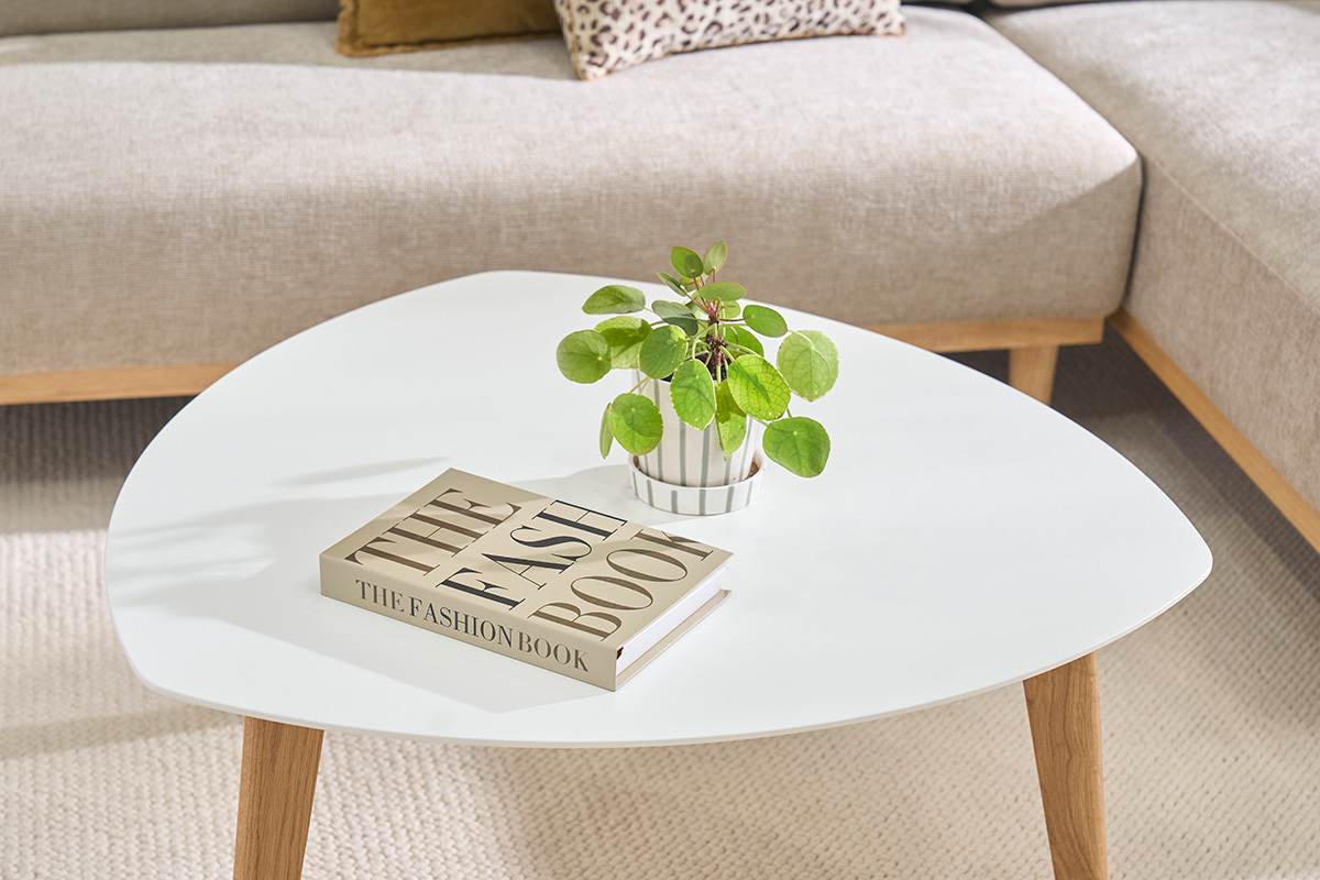Vue de dessus de la table basse scandinave blanche EKKA avec un livre et une plante