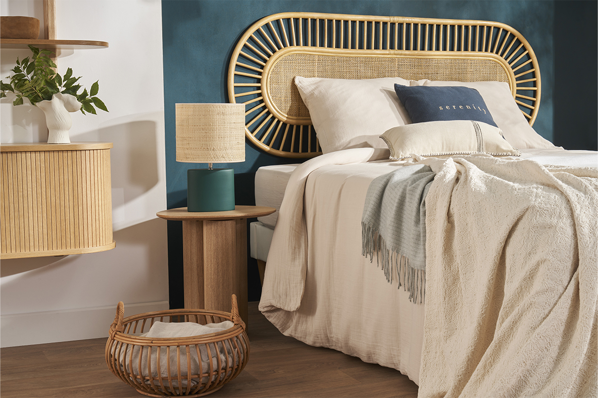 Table d'appoint HOLLEN en bois clair � c�t� d'un lit avec lampe, vue d'int�rieur.