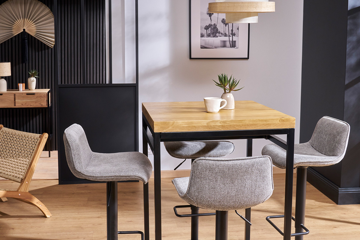 Table haute carr�e en manguier et m�tal noir, vue de trois quarts avec des tabourets gris.
