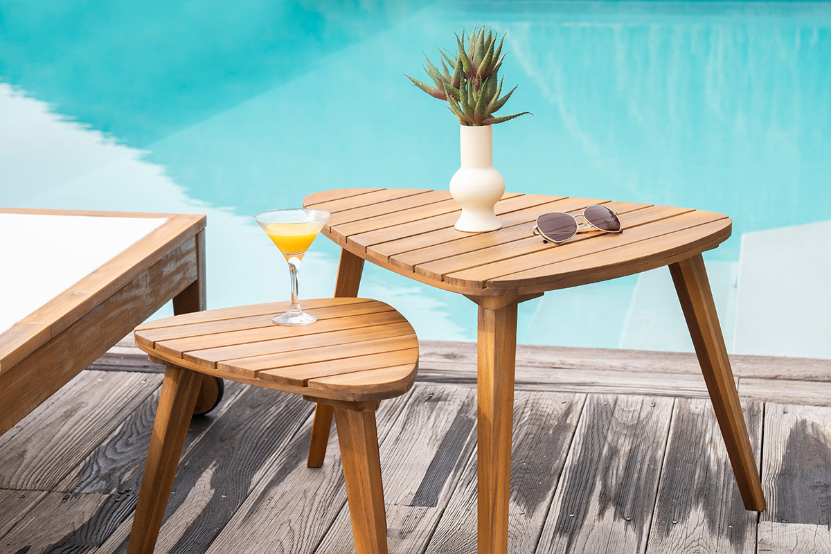 Tables basses gigognes en bois massif pr�s d'une piscine, avec un verre et une plante d�corative.