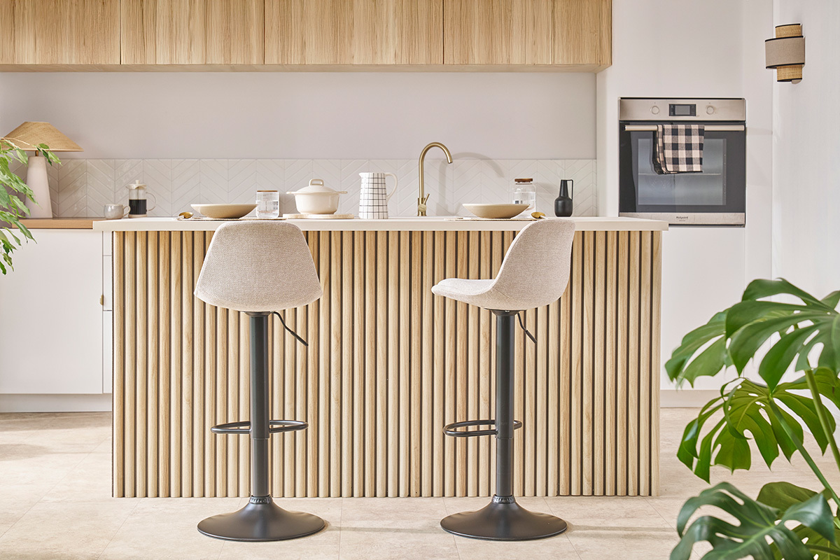 Tabourets de bar design STEEVY devant un �lot central en bois clair.