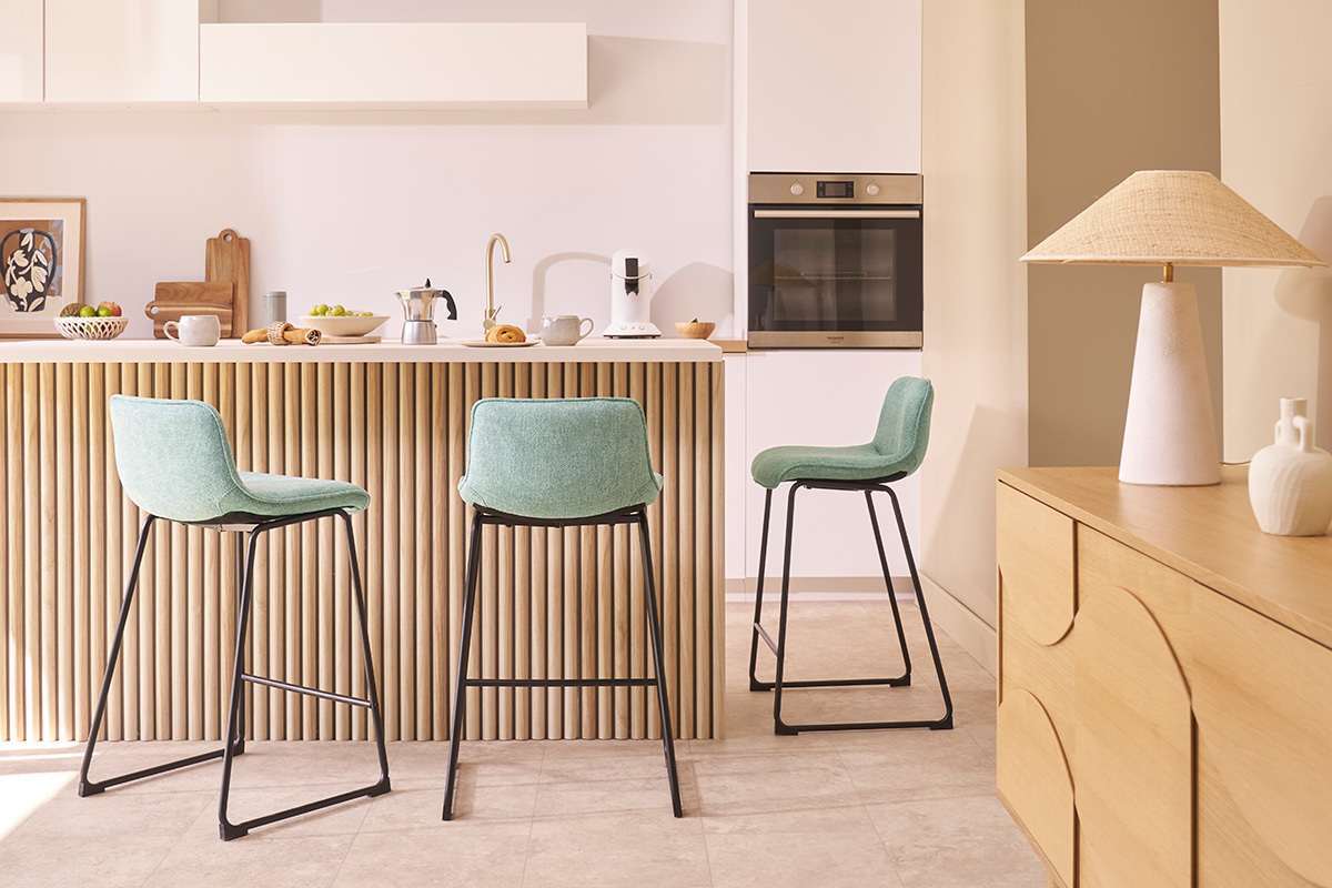 Tabourets de bar vert c�ladon en tissu et m�tal noir, devant un comptoir de cuisine.