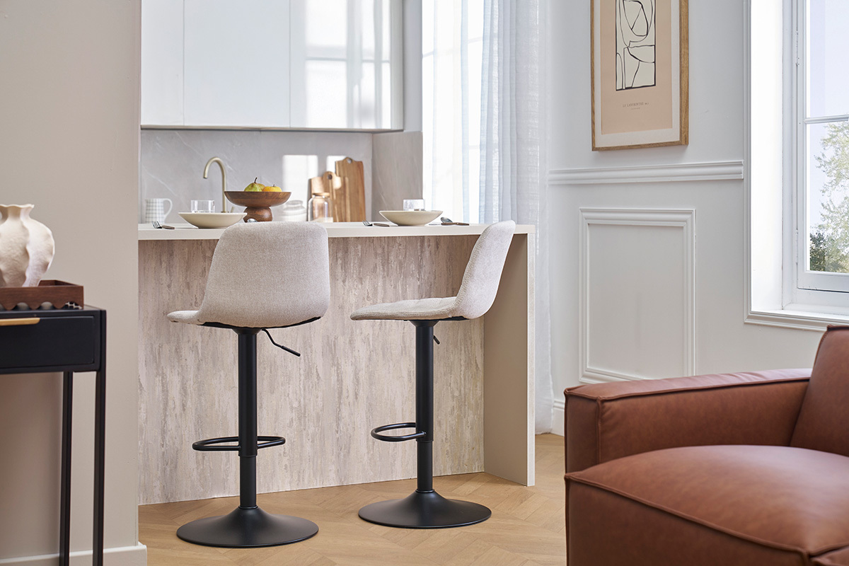 Deux tabourets de bar r�glables beige et noir, de profil, devant un comptoir.