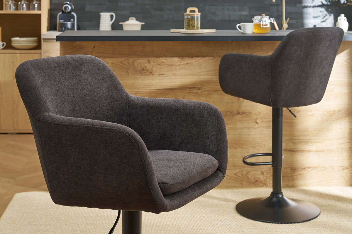 Tabourets de bar r�glables en tissu effet velours gris fonc� avec accoudoirs, en ambiance de cuisine.