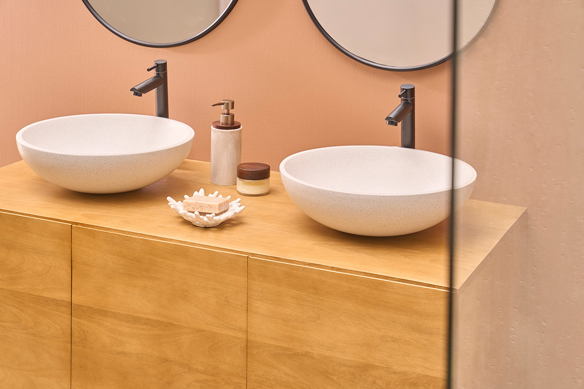 Vasque ronde en terrazzo gris LAORA de 40 cm sur plan de salle de bain en bois, vue de dessus.