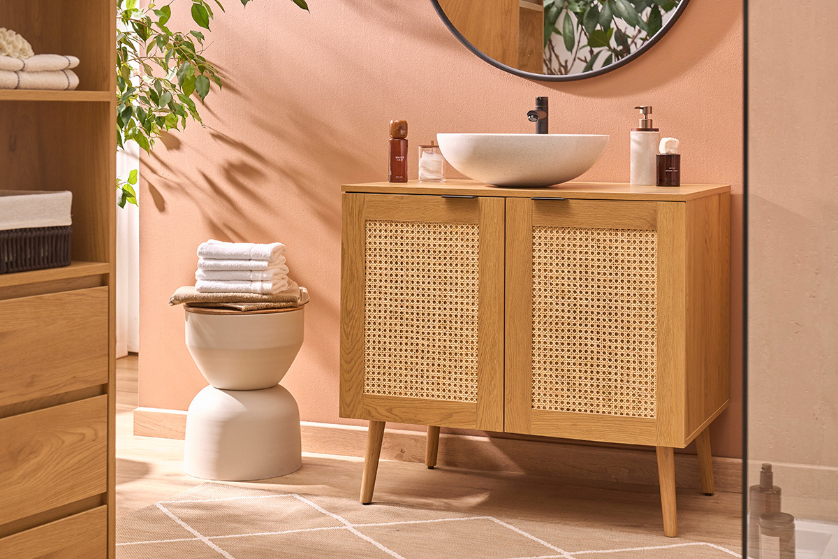 Vasque ronde en terrazzo gris D40 cm, pos�e sur un meuble de salle de bain en bois clair. Vue de c�t�.